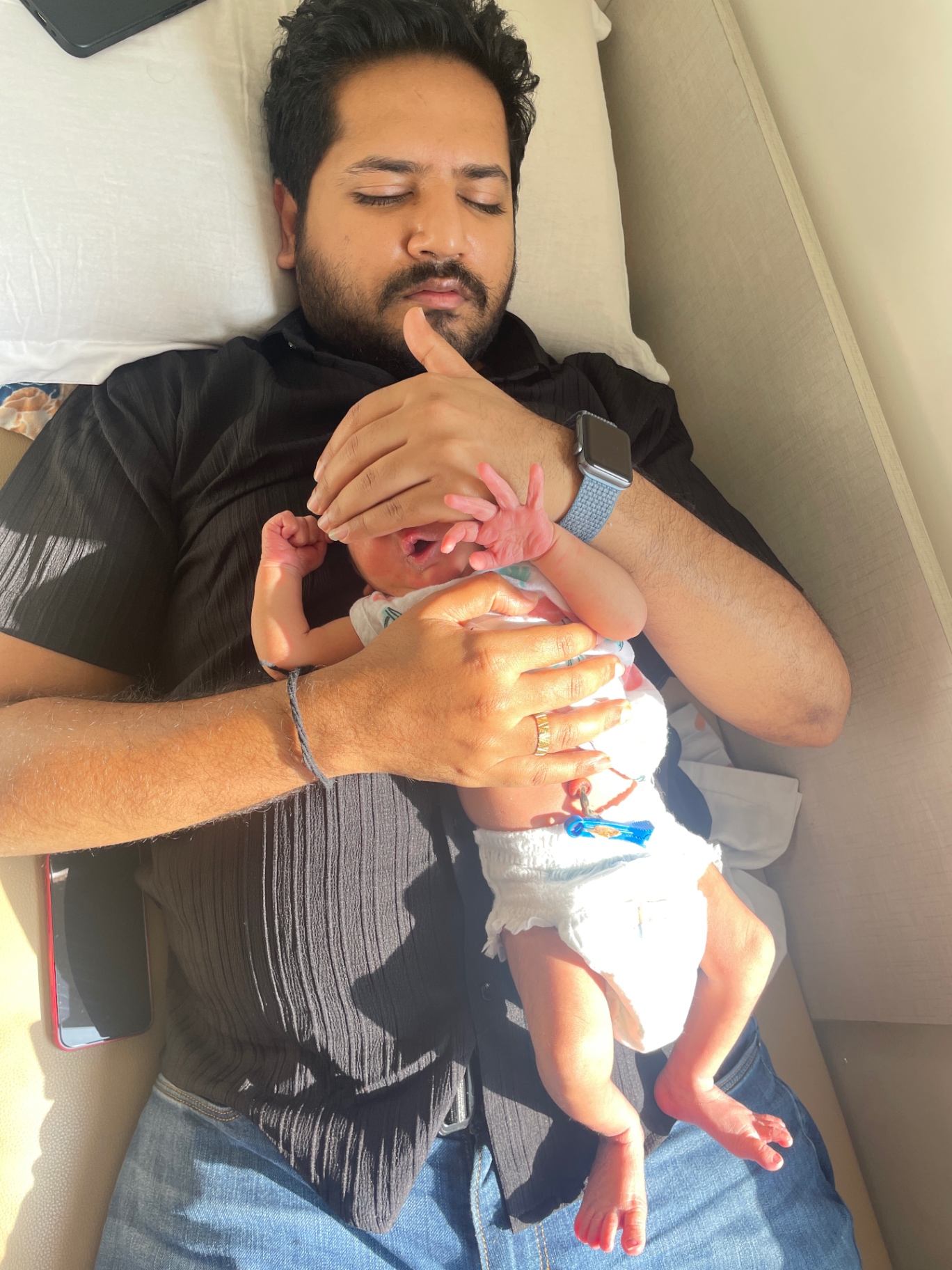 Vikram asleep with his newborn son resting on his chest