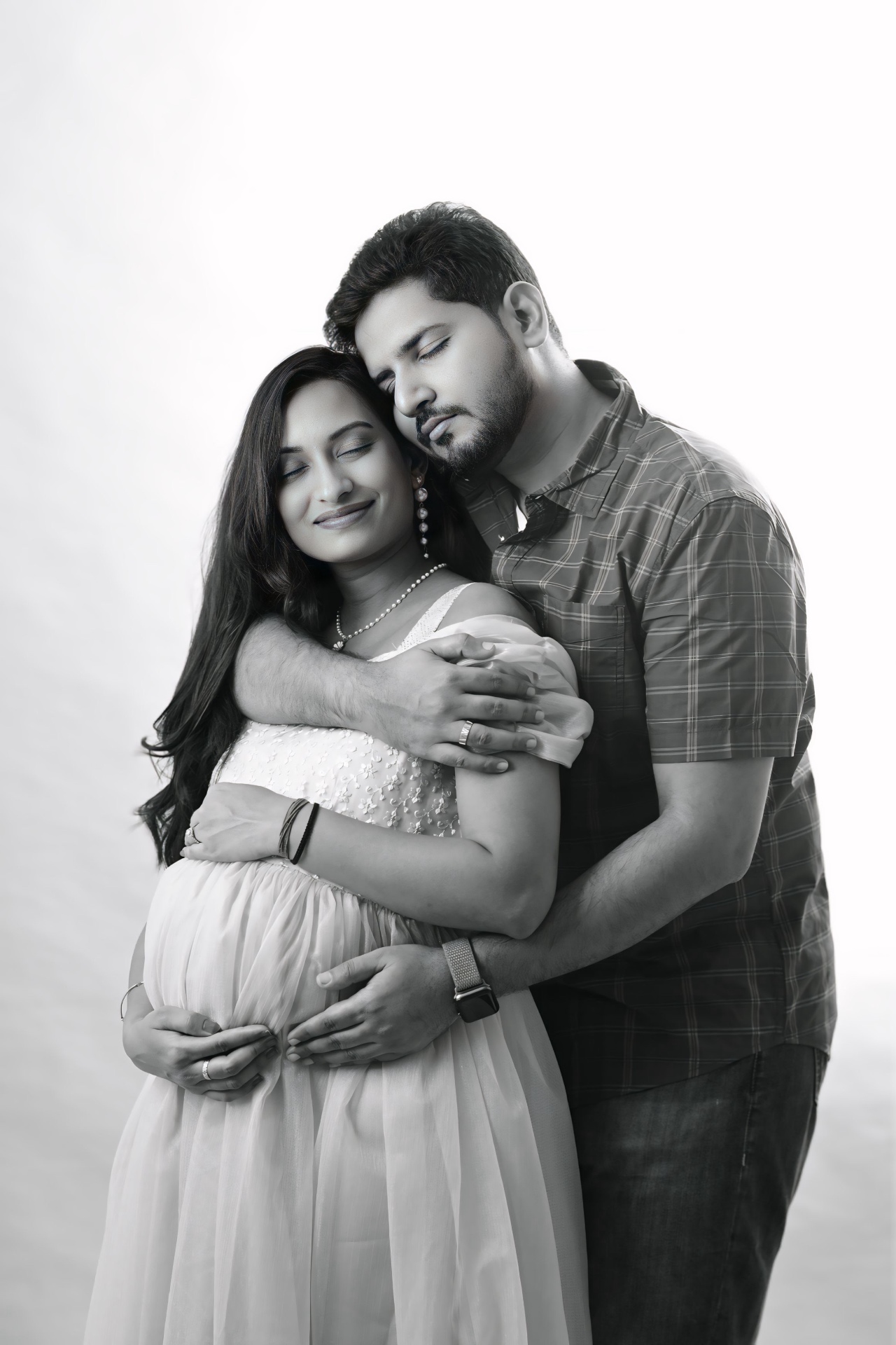 Black and white studio maternity portrait of expecting parents