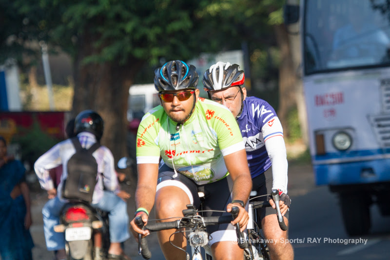 Two riders sharing a wheel on a busy Nilgiris road